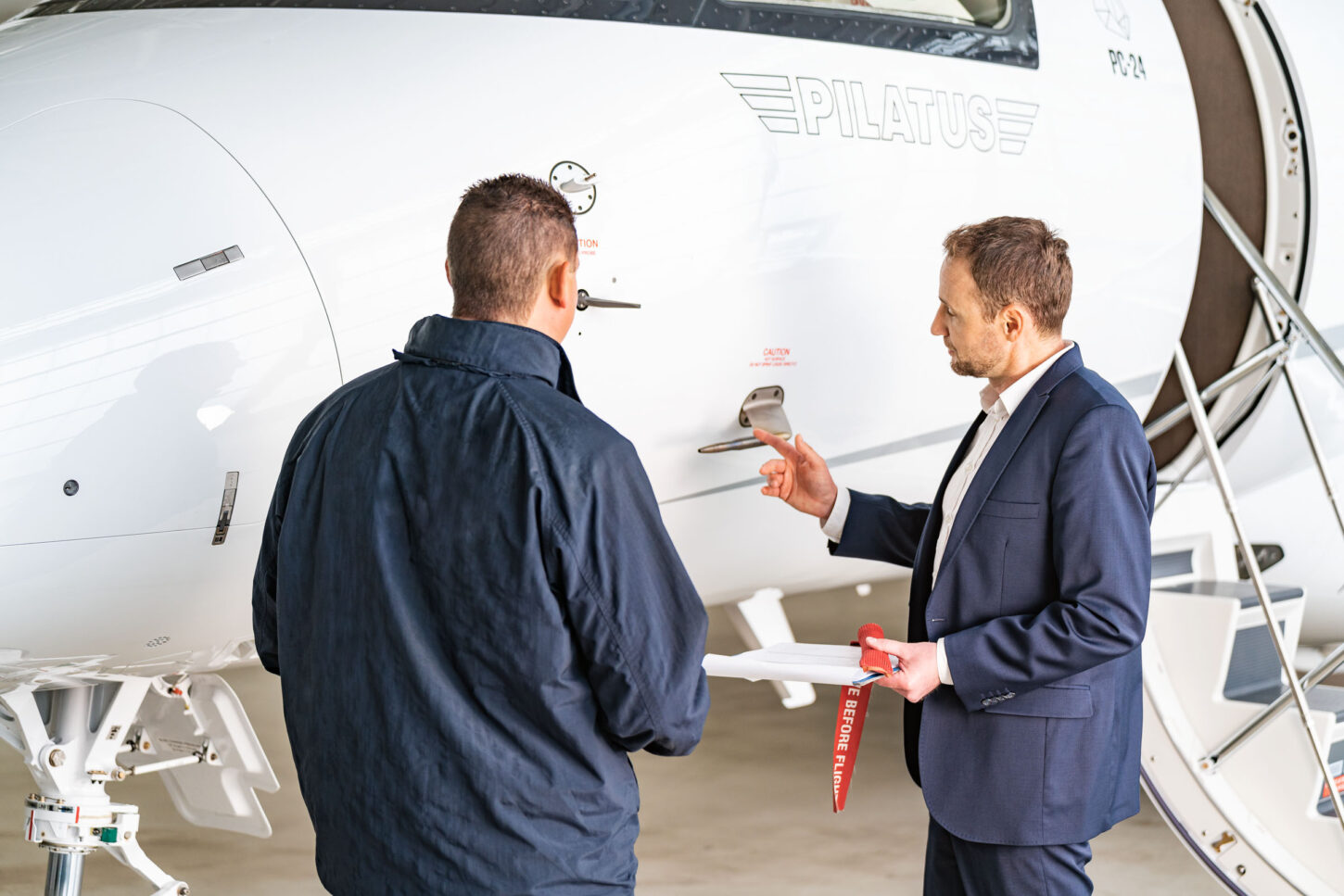 two aircraft specialists doing safety checks on a parked aircraft